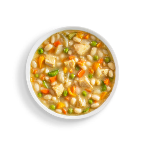 White bowl of chicken stew on a white background