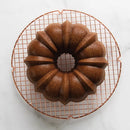 Bundt cake on a cooling rack with a white background