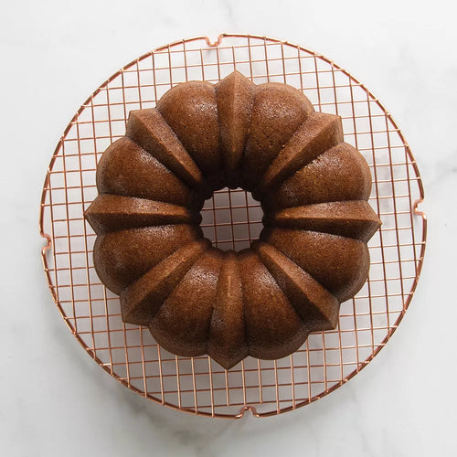 Bundt cake on a cooling rack with a white background