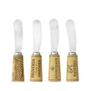 Four cheese spreaders with cork designs on a white background