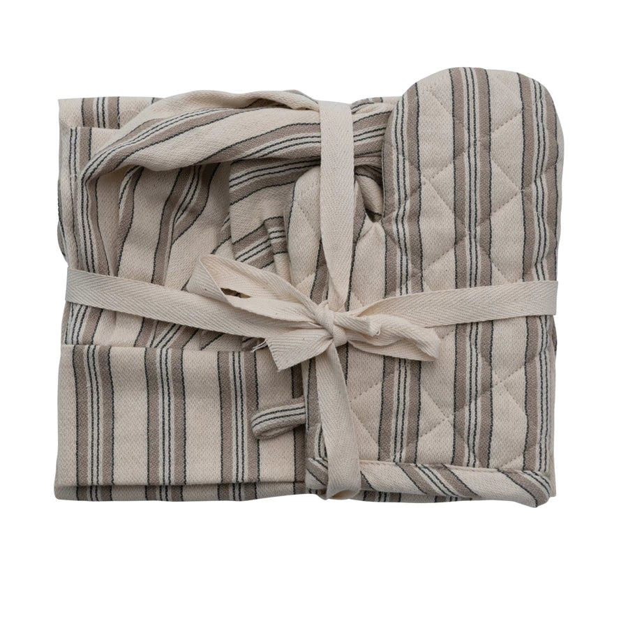 A children's kitchen apron, chef hat, and oven mitt with striped patterns, tied together with a bow.
