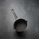Black frying pan on a dark textured surface