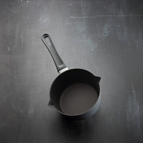 Black frying pan on a dark textured surface