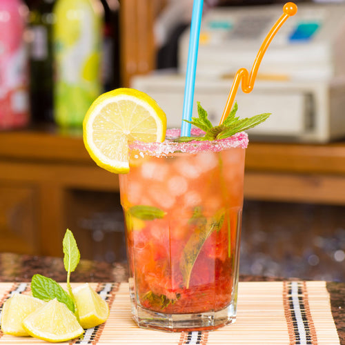 Cocktail with lemon slice and mint leaf on a bar setting.