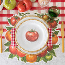 A place setting with tomato placemat, red check table runner, gold cutlery, and plates.