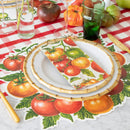 A place setting with tomato themed placemat, red check table runner, plates, and tomato napkin.