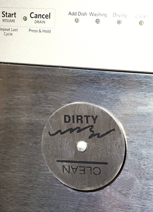 A circular dishwasher magnet with the words 'dirty' and 'clean' on a stainless steel dishwasher.