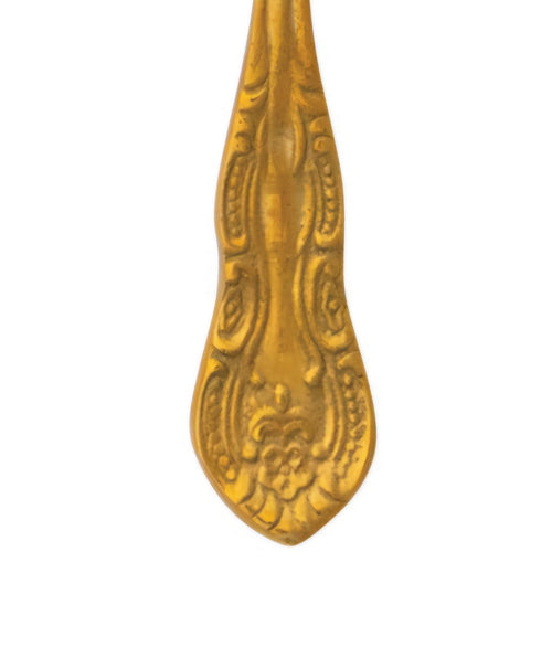 Decorative brass spoon handle on a white background