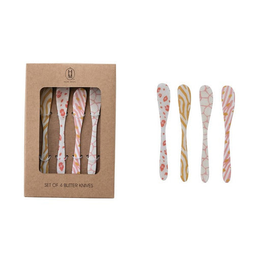 Set of four patterned butter knives with packaging on a white background