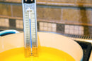 Candy thermometer in a pot of oil on a stove
