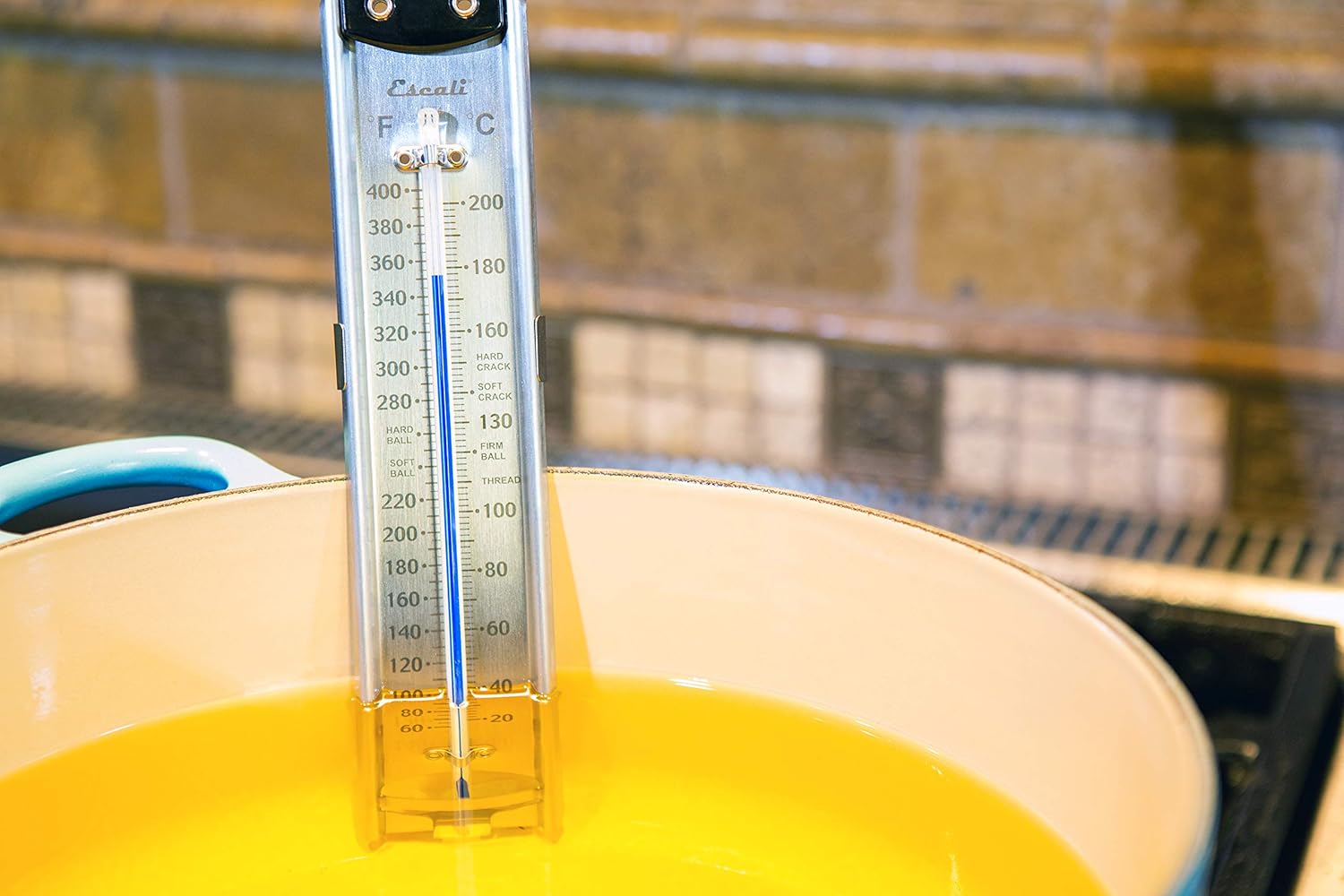 Candy thermometer in a pot of oil on a stove