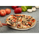 Pizza with various toppings on a stone surface with vegetables