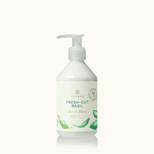 White bottle of Thymes Fresh-Cut Basil hand lotion on a white background