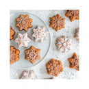 Star-shaped mini cakes on a white plate and surface with a light dusting of powdered sugar.