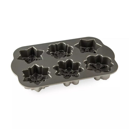 Metal cake pan with snowflake-shaped molds on a white background