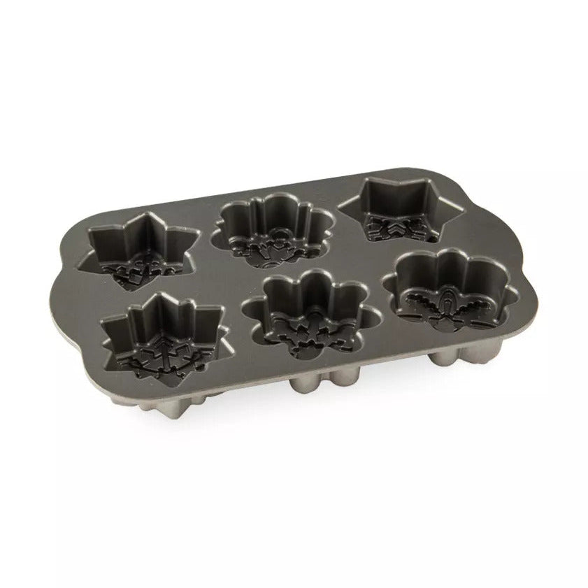 Metal cake pan with snowflake-shaped molds on a white background