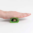 A person using a green rubber garlic peeler on a white background.