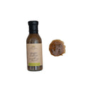 A bottle of Finch & Fennel Seasoning Ginger Scallion Sauce next to a small lump of the sauce, on a white background.