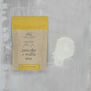 Packaging of Finch + Fennel pancake and waffle mix on a textured gray background