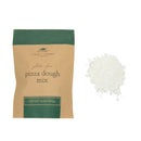 Bag of gluten-free pizza dough mix with a small pile of white dough mix on a white background