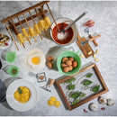 Tabletop scene with pasta-making ingredients and tools on a light gray surface.