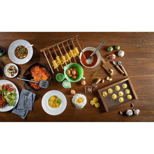 Wooden table with various food items and kitchen utensils on a white background