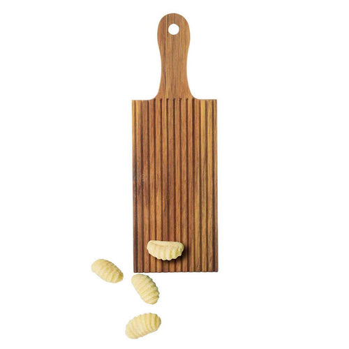 Wooden gnocchi board with handle and gnocchi on a white background