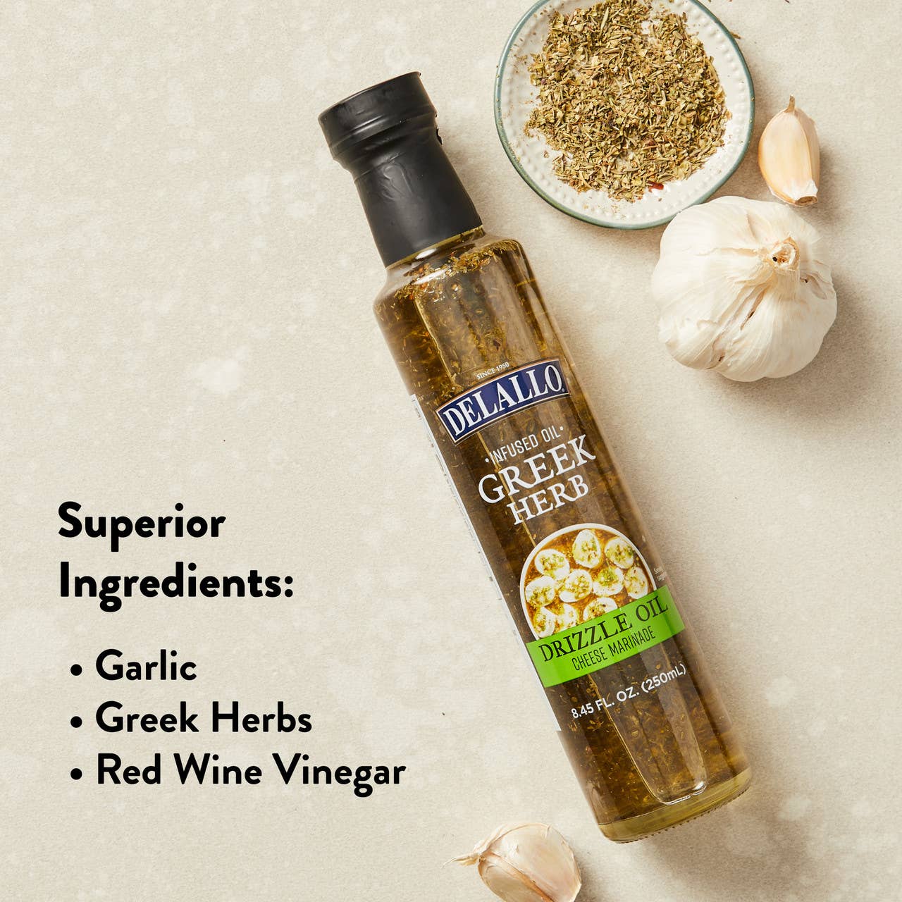 Bottle of Delallo Greek Herb Drizzle Oil with garlic and herbs on a beige background