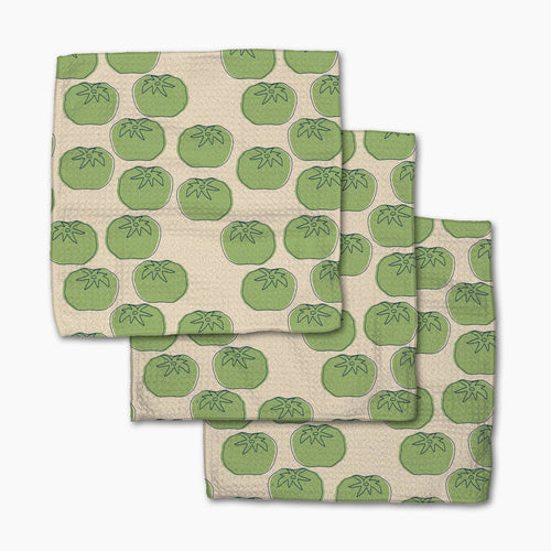 Set of three folded towels with green tomato pattern on a beige background