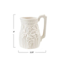 White ceramic pitcher with embossed design and measurements on a white background