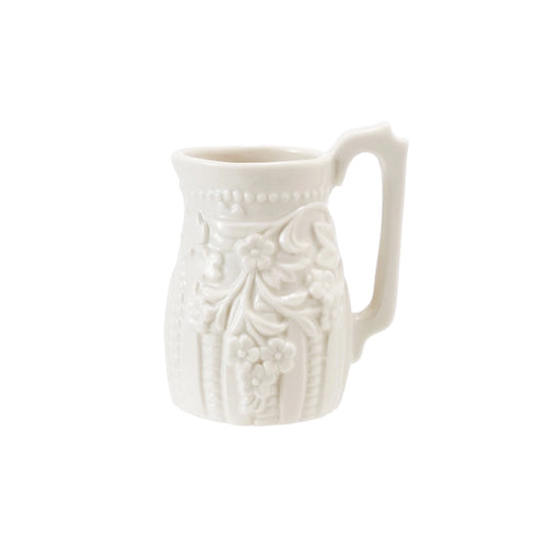 White ceramic pitcher with decorative patterns on a white background