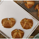 Croissants on a baking tray and cooling rack.