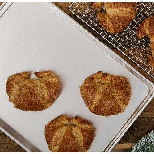 Croissants on a baking tray and cooling rack.