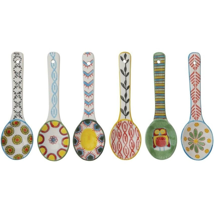 Six hand painted ceramic spoons on a white background.