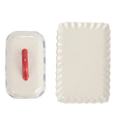 A top down look at a hand-painted butter dish with a scalloped edge dish on a white background.