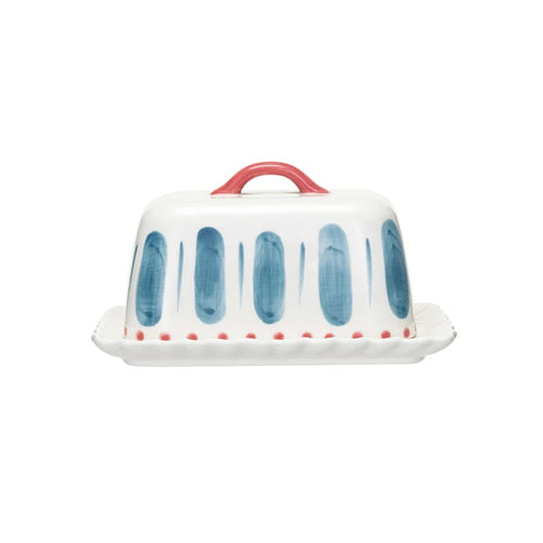 A hand-painted stoneware butter dish with red and blue accents on a white background.