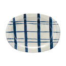 A round, hand-painted stoneware platter with a blue and white geometric pattern.