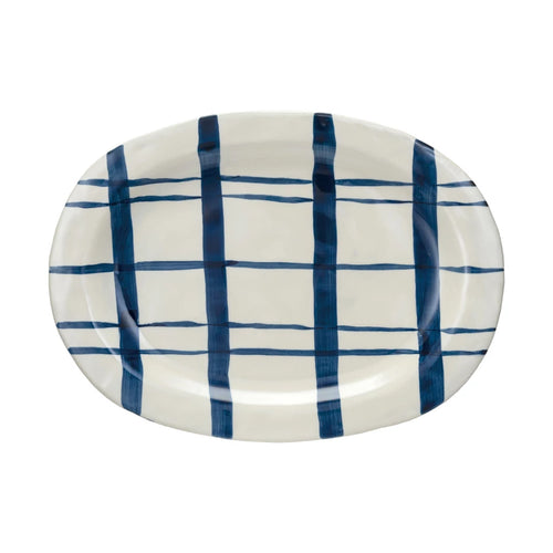 A round, hand-painted stoneware platter with a blue and white geometric pattern.