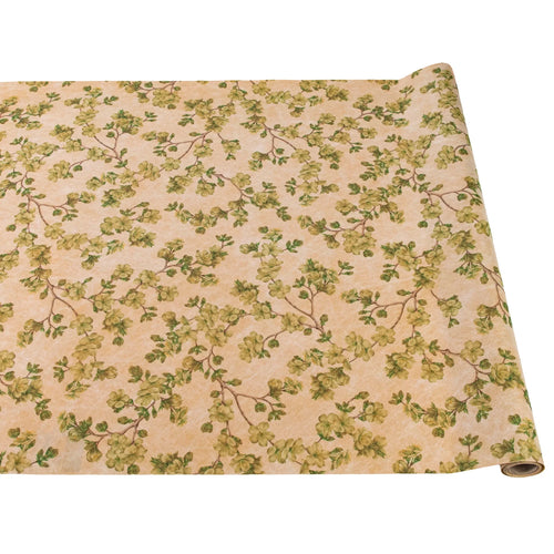 A rolled out paper table runner with a cherry blossom floral pattern in yellow and gold colors on a beige background.