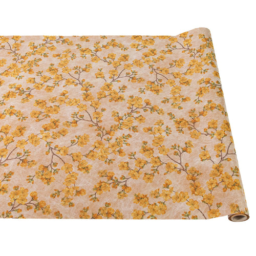 A rolled out paper table runner with a cherry blossom floral pattern in yellow and gold colors on a beige background.