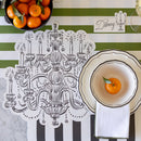 Placemat with chandelier design, bowl with orange, and striped tablecloth.