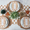 Three place settings at a table with green and orange decor and French frame placemats.