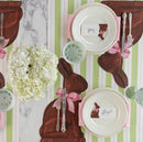Easter-themed table setting with chocolate bunny-shaped placemats and decorative elements.