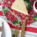Cheese with cutlery on a Christmas-themed placemat with poinsettias
