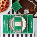 A football-themed place setting with football field styled placemats, napkins, and name card, football shaped placemat, beer, black and white striped table runner, and pizza.