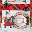Christmas-themed table setting with Santa Claus placemat, decorative plates, and Santa name card.