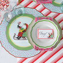 Christmas-themed table setting with decorative plates and a striped tablecloth.
