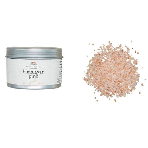 Himalayan pink salt container with a small pile of salt on a white background