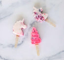 Ice pops in unicorn shapes on a marble background.