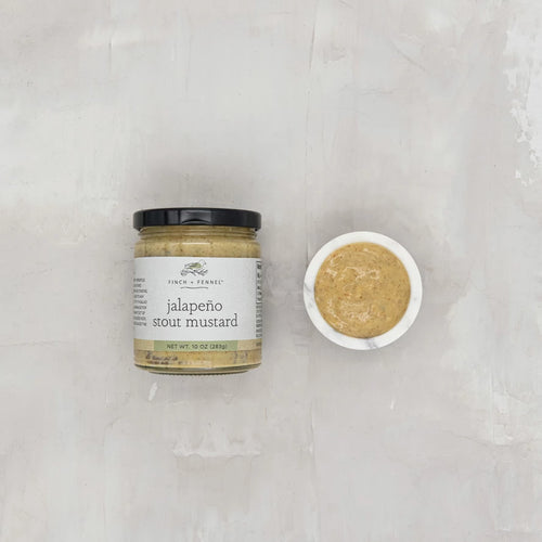 Jar of jalapeno stout mustard on a textured white surface